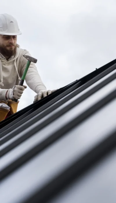 man-working-roof-with-hammer-full-shot